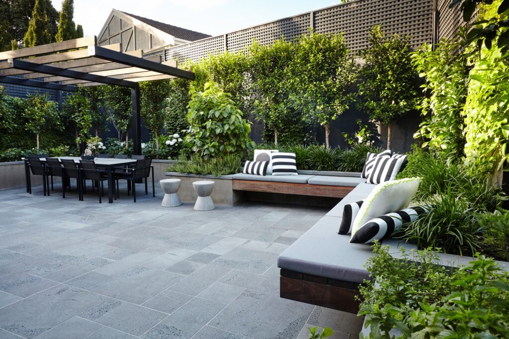 Paved terrace with built-in seating and dining area in a Toorak garden