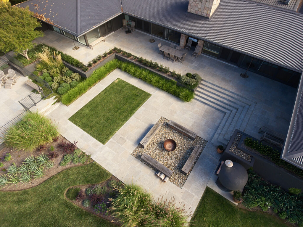 Aerial view of a landscaped courtyard with lawn, paving and fire pit